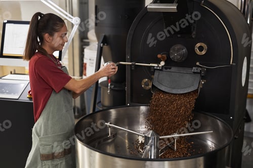 Preview: Smiling Woman Operating Coffee Roaster in Workshop