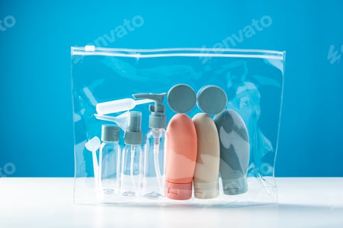 Preview: Transparent toiletry bag containing various travel-sized containers on a bright blue background