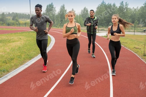 Preview: Group of active guys and girls in sportswear running down racetracks on stadium