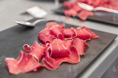Preview: Italian bresaola beef thinly sliced and served on black stone board