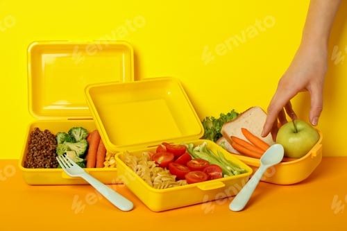 Preview: Yellow lunch box with food on a yellow background