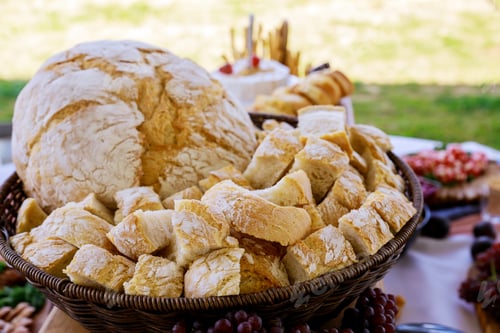 Preview: Cut crusty round bread on party table.