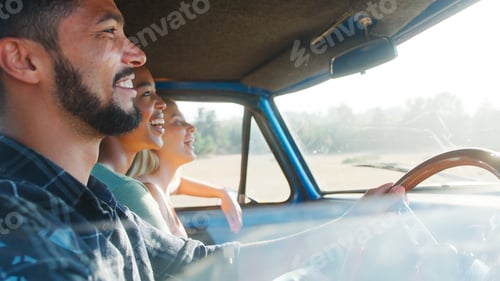 Preview: Group Of Friends Sitting In Cab Of Pick Up Truck On Road Trip Through Countryside