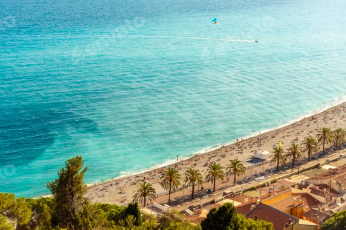 Preview: High-angle view of the bustling beach of Nice city in the french riviera with sunbathers