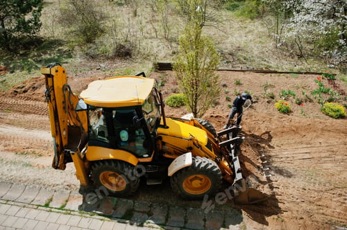 Preview: Tractor bucket levels a trench near the house