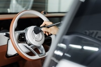 Preview: Worker wipes the steering wheel of the car, dry cleaning and interior washing. Detailing studio.