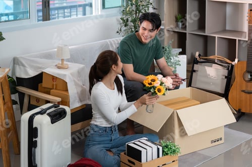 Preview: Home Decor. Couple arranging flowers and unpacking boxes in their new living room.