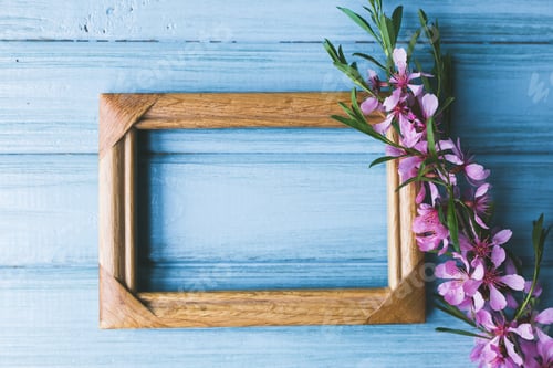 Preview: Spring flowers and frame on a blue wooden background