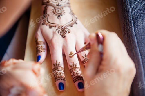 Preview: Drawing mehndi on the hand of a girl
