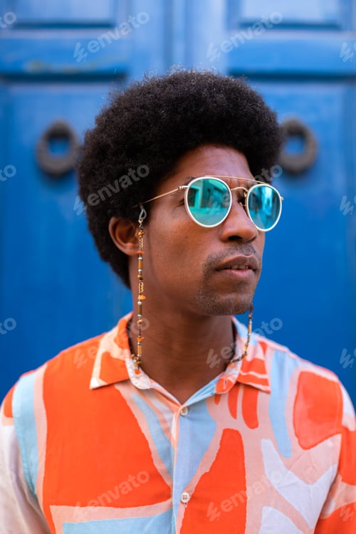 Preview: Vertical portrait of young confident and cool black man wearing sunglasses outdoors.
