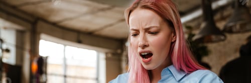 Preview: Young woman with pink hair using cellphone while studying in cafe