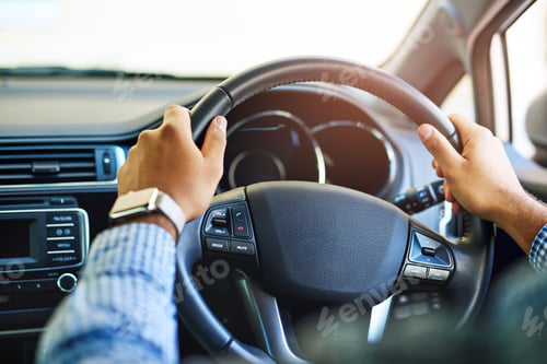 Preview: Always on the go. Cropped shot of an unidentifiable man driving a car.