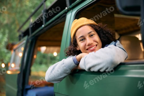 Preview: Happy black boy inside of camper van in nature looking at camera.