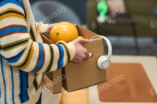 Preview: Young Man Carrying Cardboard Box with Headphones and Ball
