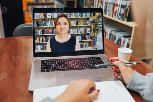 Preview: Student learning in university library. Young woman having video class listening to online course