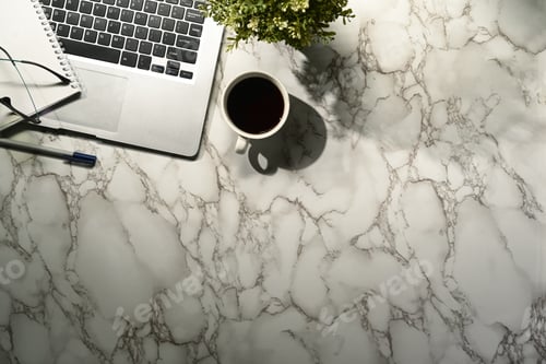 Preview: Top view workspace with laptop, coffee, notebook on marble table.