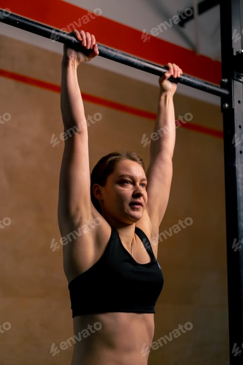 Preview: in the gym coach girl in black leggings and a top weighs on the horizontal bar
