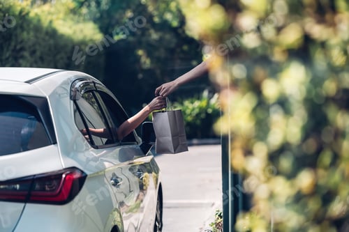 Preview: Hand Man in car receiving coffee in drive thru fast food restaurant.