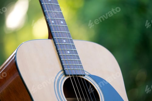 Preview: Acoustic guitar outdoors on greenery background. Concept of calm music