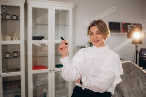 Preview: . Master of permanent makeup tool in hand in white office.