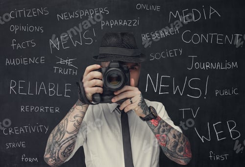Preview: Bearded dslr photographer with tattooes on his arms.