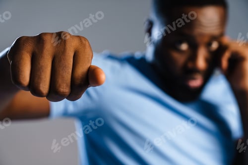 Preview: Confident african sportsman during boxing training isolated