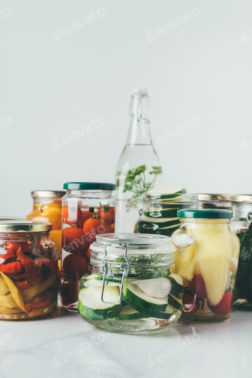 Preview: glass jars with preserved vegetables on table in kitchen