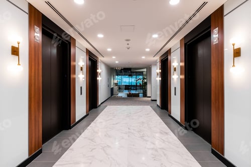 Preview: Empty, modern lobby, accessible by a long corridor, located at the entrance of a large building.