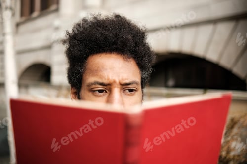 Preview: Concentrated student reading a book in university campus