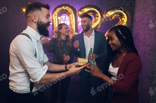 Preview: Happy beautiful couple celebrate New Year's Eve and exchanging gifts