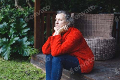 Preview: Thoughtful senior caucasian woman sitting and looking away in garden