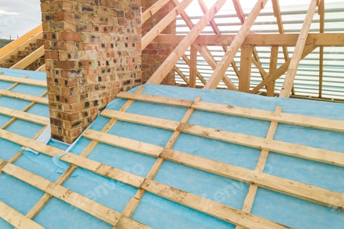 Preview: Aerial view of a brick house with wooden roof frame under construction