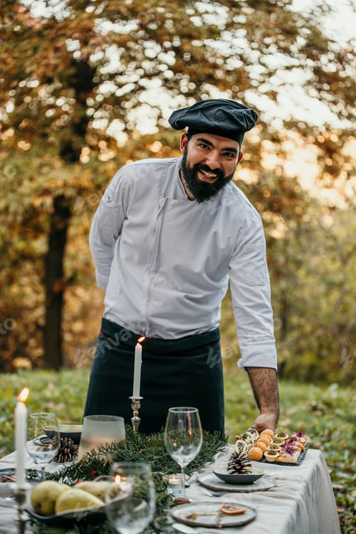 Preview: Chef presenting gourmet appetizers at an elegant outdoor dinner party