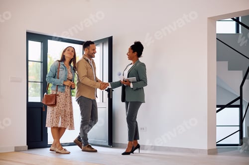 Preview: Happy couple meeting with real estate agent while buying a new house.