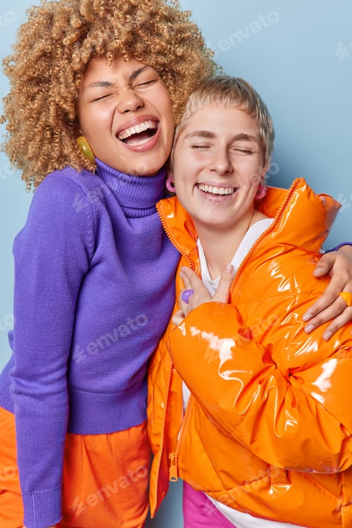 Preview: Joyful friendly beautiful women have fun embrace and laugh positively have fun together dressed in