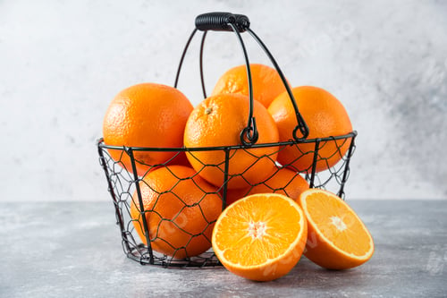 Preview: A metallic black basket full of juicy orange fruit on stone background