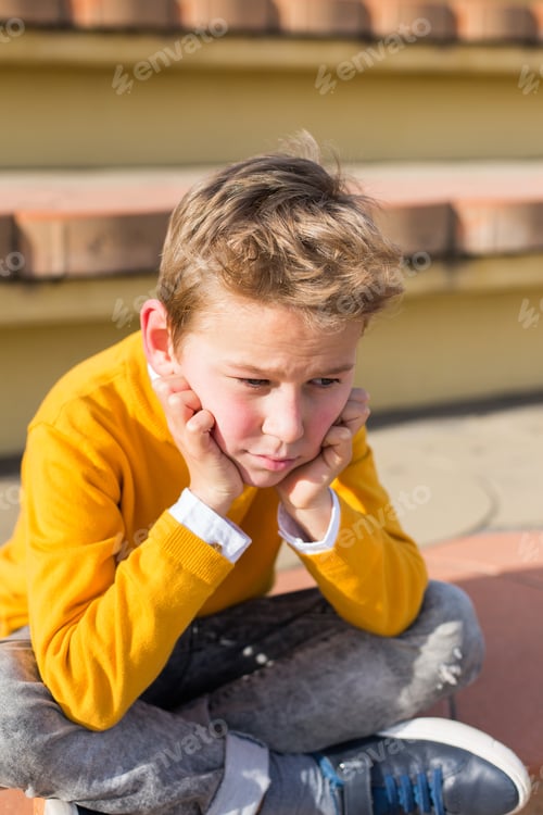 Preview: Stylish young boy, teenager is sitting at the stadium, outdoors