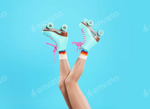 Preview: Young woman with retro roller skates on color background, closeup