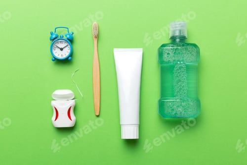 Preview: Mouthwash and other oral hygiene products on colored table top view with copy space.