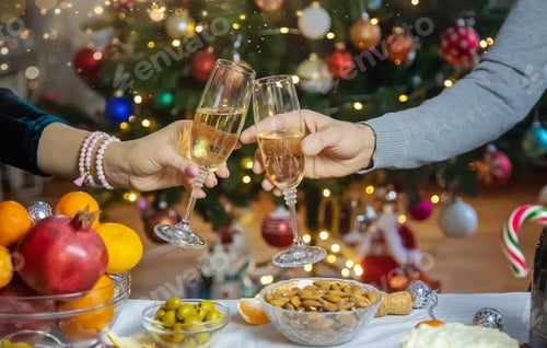 Preview: Champagne in hand against the background of the Christmas tree. People. Selective focus.