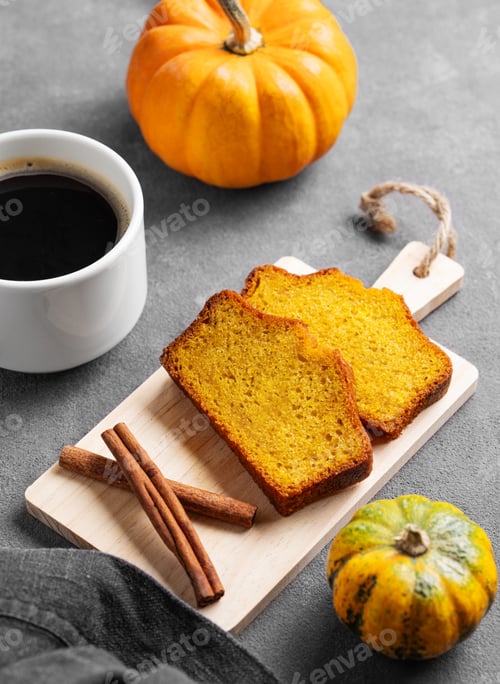 Preview: Slices of pumpkin sweet bread with cinnamon on a wooden board on a dark background