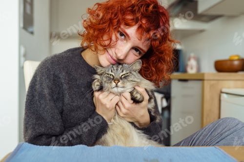 Preview: Portrait red-haired curly young woman with beloved fluffy domestic cat
