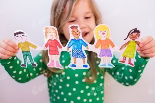 Preview: girl holding paper homemade garland of people of different races. Happy international children day