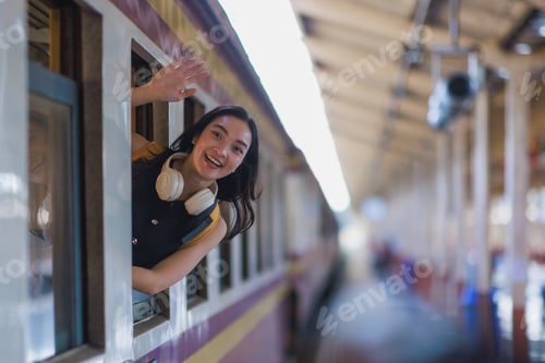 Preview: Young woman traveling by train waving goodbye cheerful
