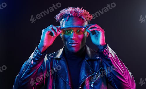 Preview: In glasses. Futuristic neon lighting. Young african american man in the studio