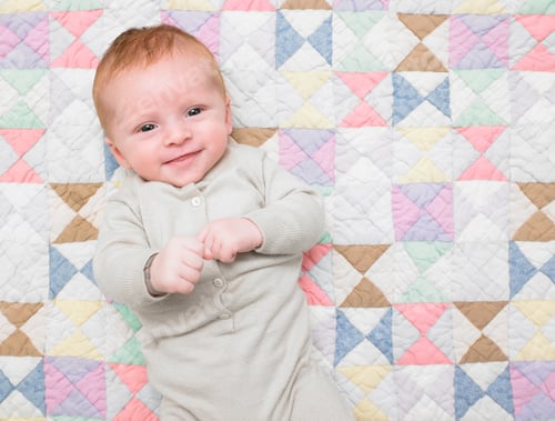 Preview: Smiling baby on quilt