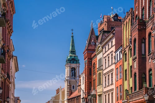 Preview: Church of the Holy Spirit surrounded by buildings under the sunlight and a blue sky in Torun, Poland