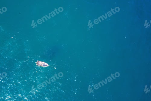 Preview: top view of a white boat anchored in the blue sea