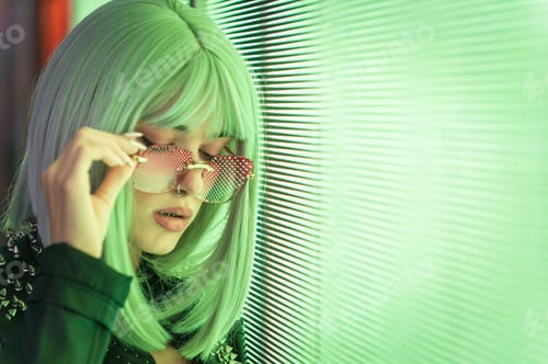 Preview: Image of a beautiful young woman posing against a led panel.