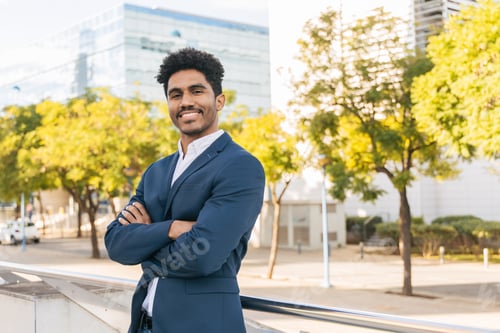 Preview: Confident ethnic man standing on city street